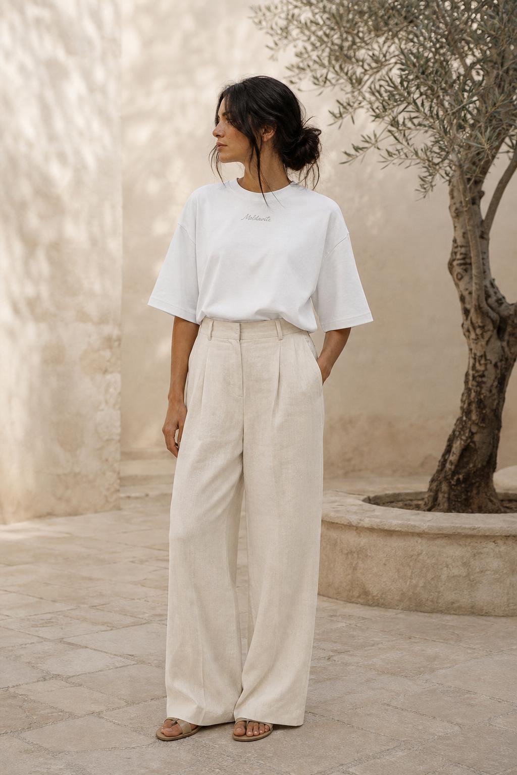 Woman wearing the Calm Not Noise boxy tee in a stone courtyard